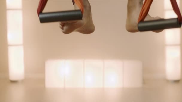 Γυμναστική τέντωμα στην αιώρα στο στούντιο γιόγκα.Κορίτσι πρακτική μύγα γιόγκα στην αιώρα — Αρχείο Βίντεο