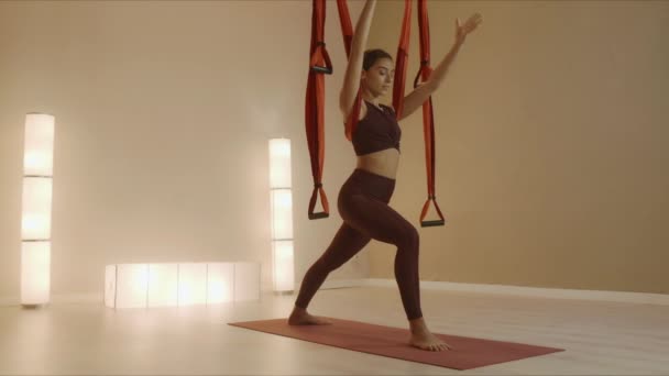 Zdolna kobieta pozuje na wojowniczki z paskami do jogi. Dziewczyna ćwiczy jogę w klasie — Wideo stockowe