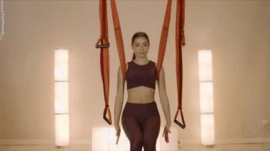 Yoga dersinde elini uzatan bir kadın. Stüdyoda hamakla yoga yapan kız.