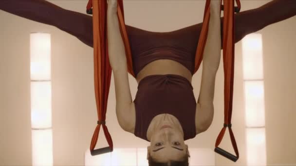 Женщина делает перевернутую звездную позу на yoga fly class.Lady практикуя yoga в гамаке — стоковое видео