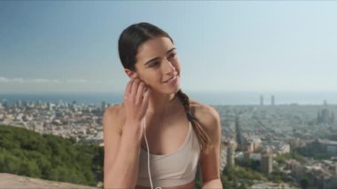 Kulaklıklı kadın dışarıda meditasyon yapıyor. Kulaklıkla müzik dinleyen yoga eğitmeni.