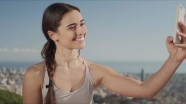 Akıllı telefondan selfie çeken bir kadın. Telefon kamerasında barış işareti gösteren bir kız