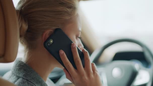 Visão traseira da mulher falando telefone no carro. Feminino inclinado no volante no carro — Vídeo de Stock