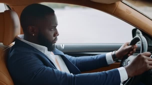 Vista lateral del hombre afro conduciendo solo en el coche. Hombre africano a caballo en vehículo moderno — Vídeos de Stock