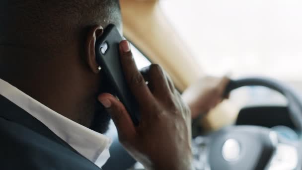 Vista trasera del hombre africano hablando por teléfono en el coche. Hombre sentado detrás del volante — Vídeos de Stock