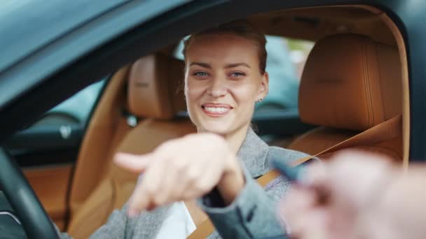 Fechar-se sorrindo mulher sentada em carro novo. Mulher feliz recebendo chaves de carro novo — Vídeo de Stock