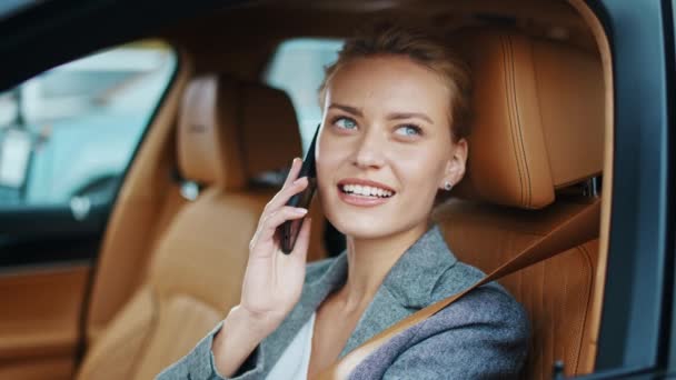 Улыбающаяся деловая женщина, смотрящая в машину. Женщина сидит в стильном костюме в машине — стоковое видео