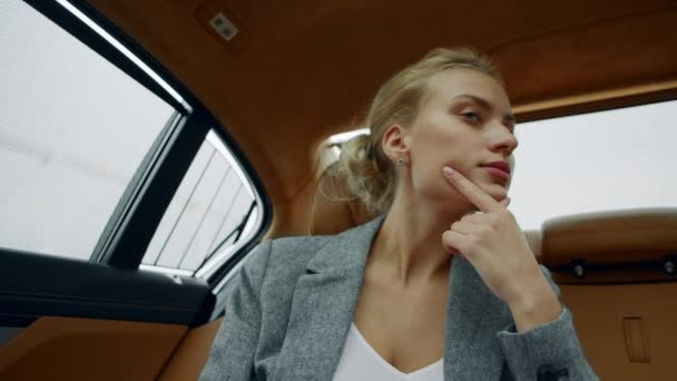 Retrato de una mujer enfocada sentada en el auto. Doubtdul chica pensando asiento trasero en el coche — Vídeos de Stock