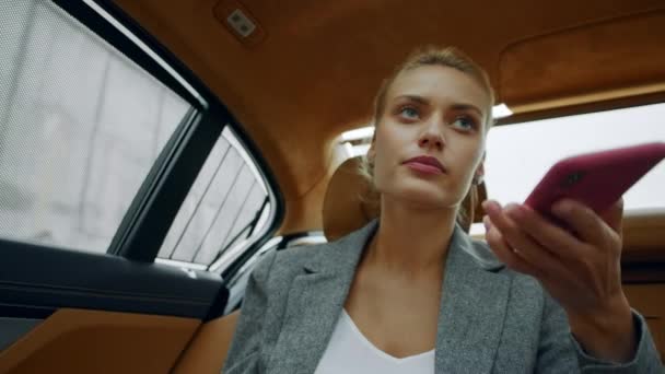 Retrato de una mujer montando en el asiento trasero del coche. Mujer llamando al teléfono móvil en el coche — Vídeo de stock