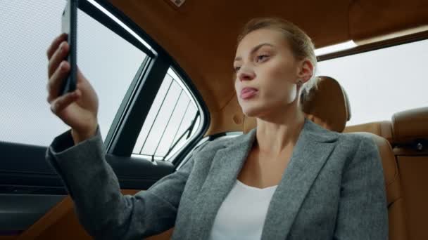 Closeup focused executive woman making video chat at vehicle. Woman using mobile — Stock Video