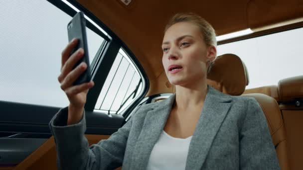 車でビデオ通話をしている美しい実業家。顔に触れる集中女性 — ストック動画