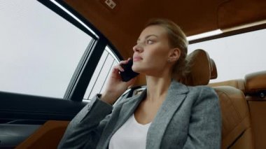 Ciddi bir iş kadınının arabasından telefon geliyor. Yorgun kız cep telefonunu arıyor.