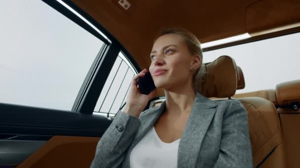 Close-up ontspannen zakenvrouw bellen mobiele telefoon in luxe auto. — Stockvideo