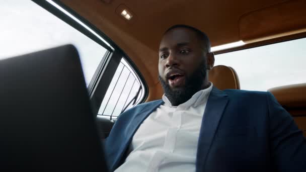 Portret zdziwionego Afrykanina, Amerykanina dostającego dobre wieści w luksusowym samochodzie. — Wideo stockowe