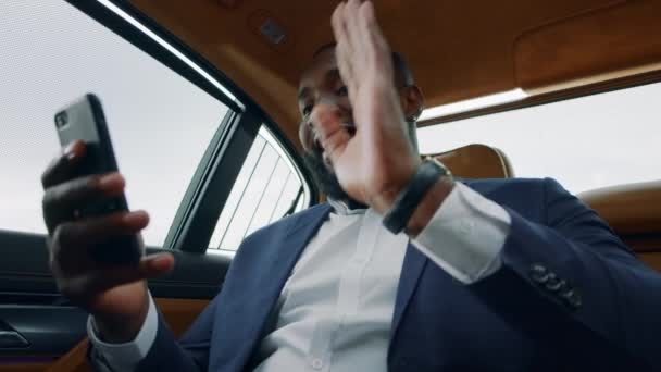 Homem africano de perto a fazer uma chamada de vídeo no carro. afro homem acenando mão no veículo — Vídeo de Stock