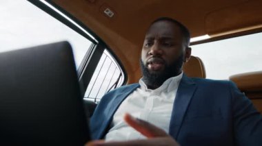 Yakın plan. Ciddi bir Afro-Amerikan erkeği arabasındaki tablet bilgisayardan video çağrısı alıyor.