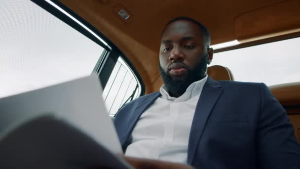 Bsinessman leyendo documentos en el coche. Hombre sentado con papeles en un lugar de trabajo remoto — Vídeos de Stock