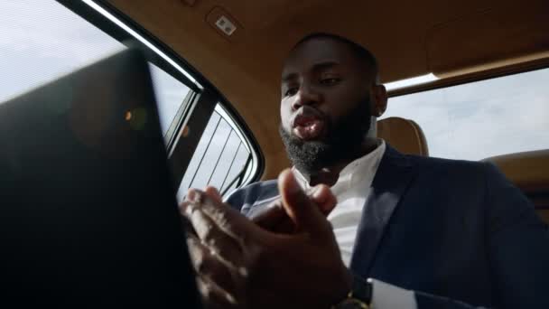 Um afro-americano stressado a discutir no carro. Homem de negócios agressivo gritando — Vídeo de Stock