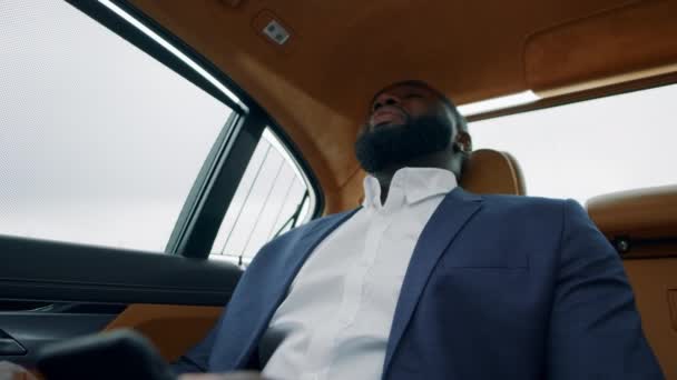 Африканський бізнесмен отримує погані новини по телефону. Розчарований чоловік у розкішному автомобілі. — стокове відео