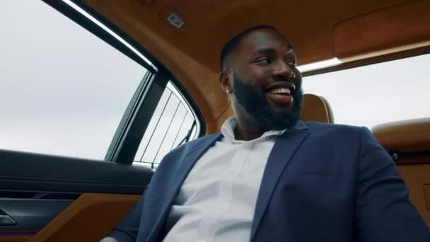 Retrato del hombre de negocios mirando hacia otro lado al coche. Hombre africano mostrando el teléfono en el coche — Vídeo de stock