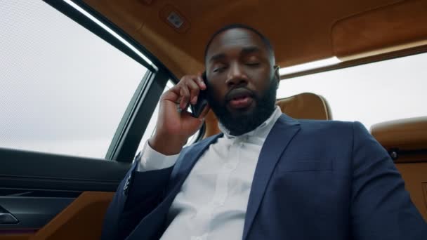 Веселый африканский мужчина звонит по телефону в машине. Афро-бизнесмен улыбается автомобилю . — стоковое видео