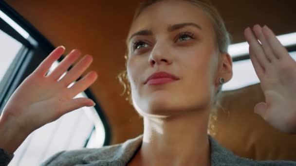 Porträt einer hübschen Geschäftsfrau, die im Auto tanzt. Mädchen bewegt Hände in modernem Auto — Stockvideo