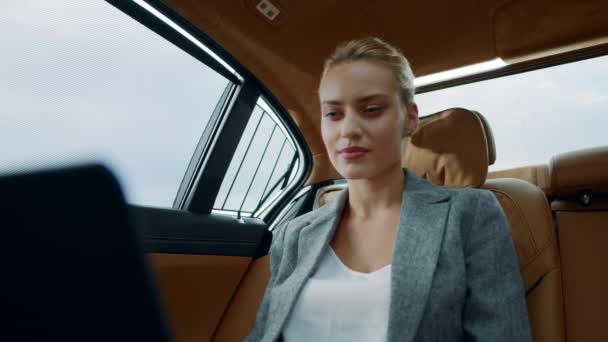 Meglepő, hogy egy üzletasszony laptopot használ a hátsó ülésen. Üzletasszony mosolyog az autóra. — Stock videók