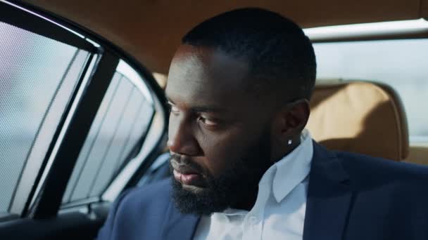 Primo piano preoccupato uomo d'affari sensazione di stress in auto. Triste uomo africano faccia — Video Stock