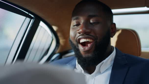 Portré a vidám afrikai üzletemberről, aki kitalált dokumentánsokat keres az autóban.. — Stock videók