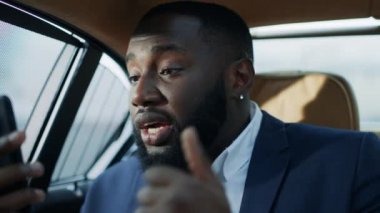 Stresli Afrikalı bir adam arabada video görüşmesi yapıyor. Kızgın afro adam kötü haber alıyor.