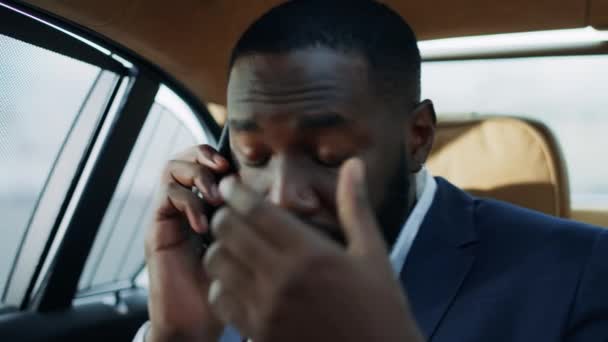Preocupado afroamericano hombre recibiendo malas noticias en el teléfono móvil en coche moderno . — Vídeos de Stock