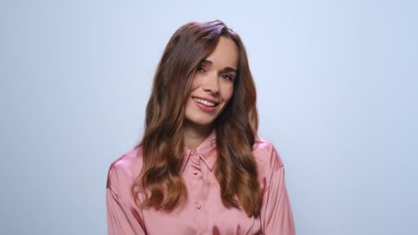 Geschäftsfrau flirtet mit Kamera auf blauem Hintergrund. Fröhliches Frauenporträt — Stockvideo
