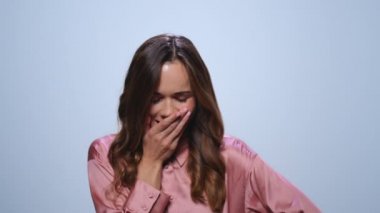 İş kadını mavi arka planda esniyor. Kadın yönetici sabah uyanır.