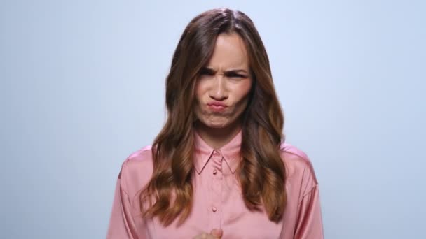 Businesswoman making funny faces in studio. Girl laughing on blue background — Stock Video