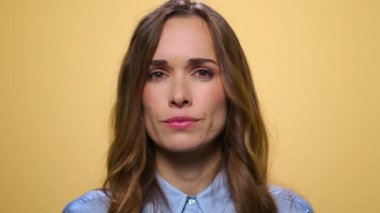 Pozitif kadın kameraya başını sallıyor. Çekici bir kadın stüdyoda duruyor.