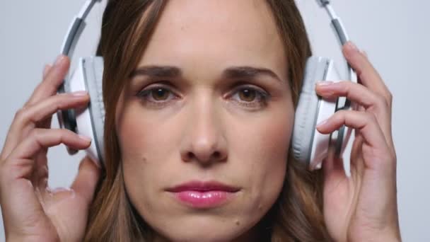 Zakelijke vrouw zet op hoofdtelefoon in studio.Girl luisteren muziek in oortelefoons — Stockvideo