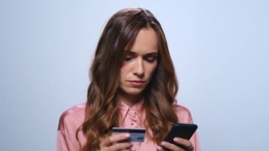 İş kadını stüdyoda akıllı telefondan online alışveriş yapıyor. Kredi kartı kullanan kadın.