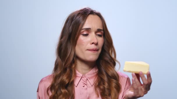 Empresaria trastornada mirando pastel en la mano. Mujer oliendo pastel de queso — Vídeos de Stock