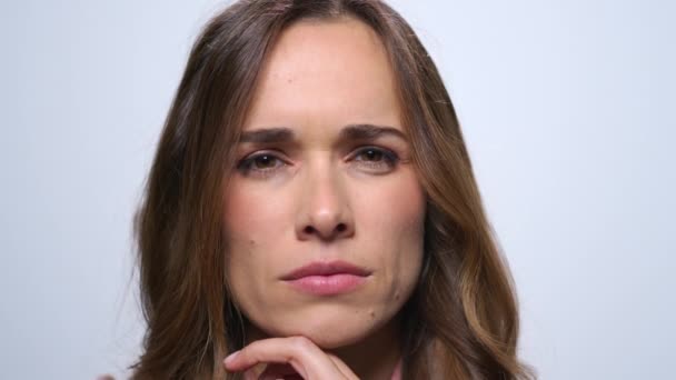 Thoughtful businesswoman on blue background. Girl holding hand at face — Stock Video