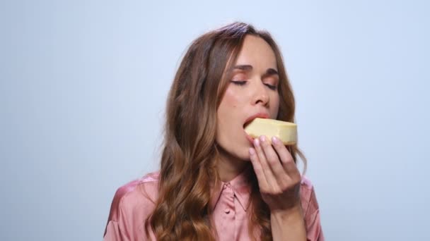 Улыбающаяся деловая женщина ест торт. Голодная женщина пробует чизкейк в студии — стоковое видео