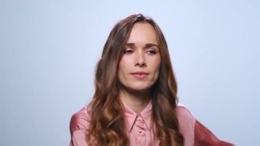 Mavi arka planda dans eden iş kadını. Stüdyoda kameraya gülümseyen kadın