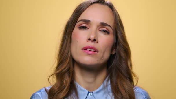 Attraktiv kvinna visar tystnad tecken på gul bakgrund. Flicka hålla hemligt — Stockvideo