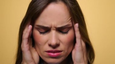 Kamera karşısında migreni olan bitkin bir kadın. Yorgun kız baş ağrısı çekiyor.
