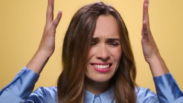 Femme stressée debout sur fond jaune. Femme touchant la tête avec les mains — Video