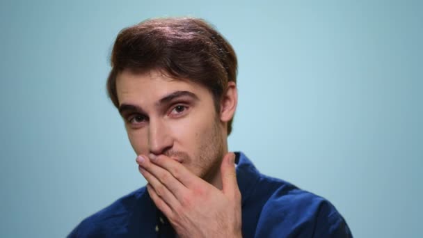 Pohledný muž posílá vzdušný polibek před kameru. Vousatý chlap flirtování na modrém pozadí — Stock video