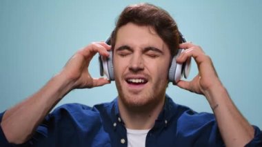 Yakışıklı adam kulaklık takıyor. Kulaklıkla müzik dinleyen adam.