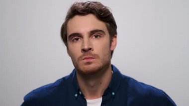 Kızgın adam kameraya bakıyor. Stüdyoda elleri titreyen hoşnutsuz bir adam.