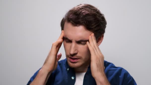 Der Mann hält die Hände auf dem Kopf. Nahaufnahme müde Kerl mit Kopfschmerzen im Studio — Stockvideo