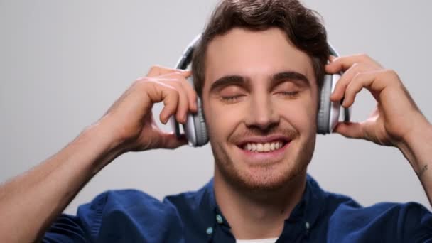 Schöner Mann, der über Kopfhörer Musik hört. Kerl genießt Musik in Kopfhörern — Stockvideo