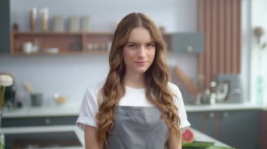 Mutfakta gülümseyen genç bir kadın. Güzel ev hanımı fotoğraf makinesini eve bırakıyor.